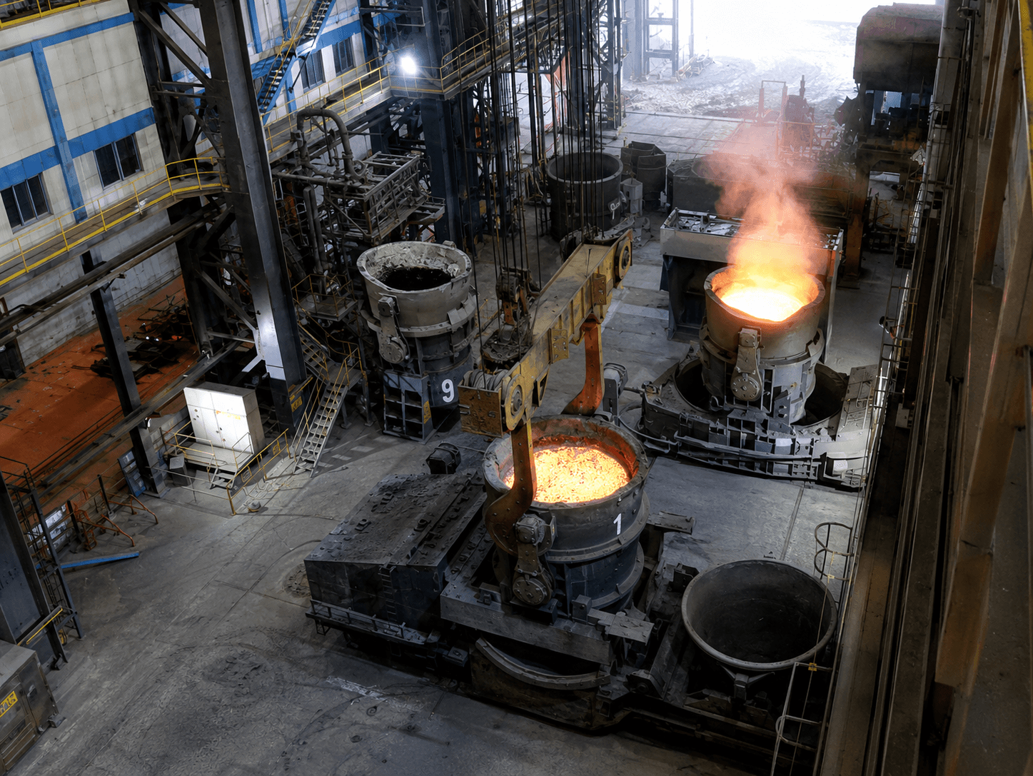 A working ladle bay: multiple numbered ladles at different stages — one being lifted, one fuming, one empty.
